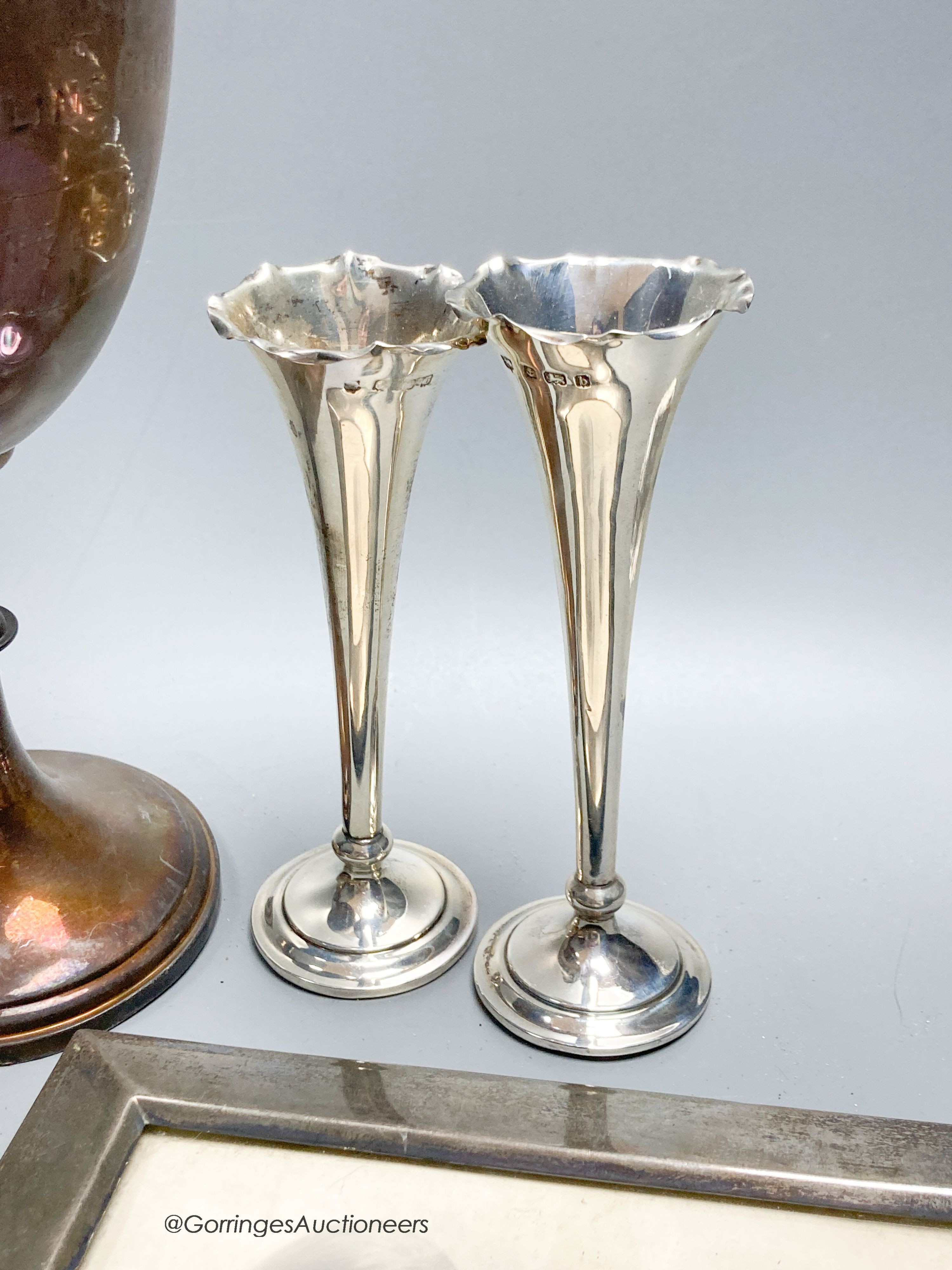 Sundry small silver including a trophy goblet, 22.5cm, napkin rings, two photograph frames, match tidy, spill vases, brushes, white metal tots and box etc.